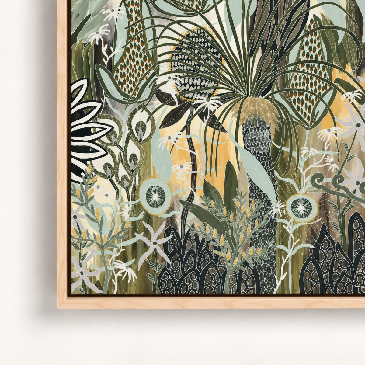 A framed botanical art print featuring an intricate pattern of stylized leaves, flowers, and tropical foliage in muted green, beige, black, and soft yellow tones, housed in a light natural wood frame.