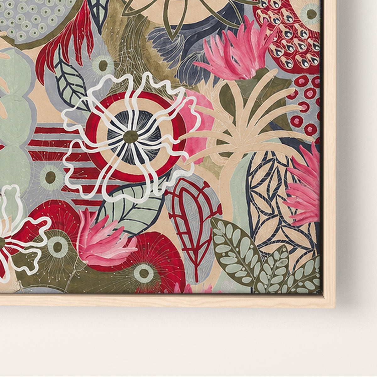A close-up of a framed floral artwork with layered botanical shapes in pink, red, sage green, beige, and gray on a white wall background.
