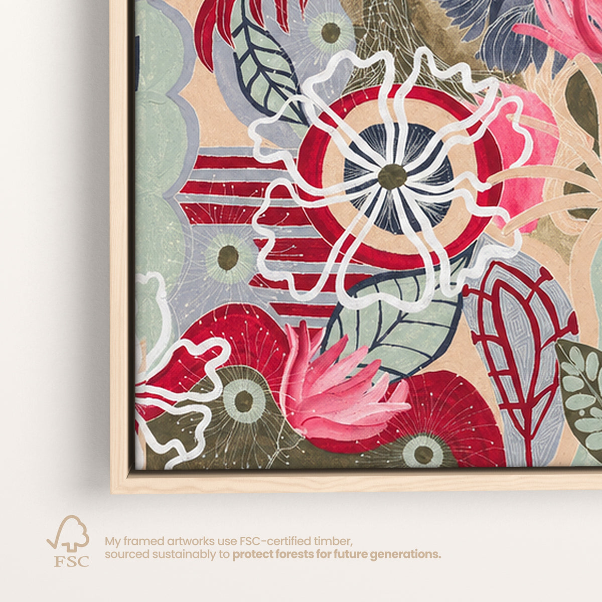 A framed abstract floral artwork with layered red, pink, white, blue, green, and beige organic shapes, shown at an angle against a light gray background. Small text below references FSC-certified timber.