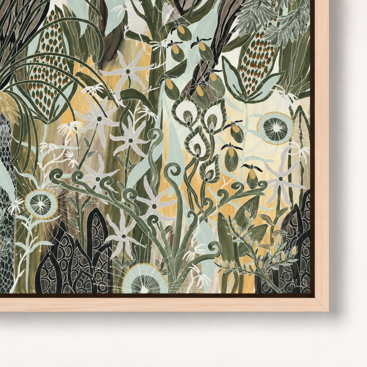 A framed botanical art print featuring an intricate, stylized illustration of wildflowers, leaves, and abstract plant forms in muted green, cream, yellow, and black tones, set in a light natural wood frame.