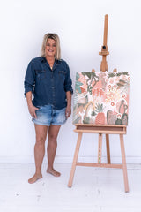 Painting by Anna Lohe on easel called Aperol Sunset. Colour palette is peach, terracotta and features botanical imagery